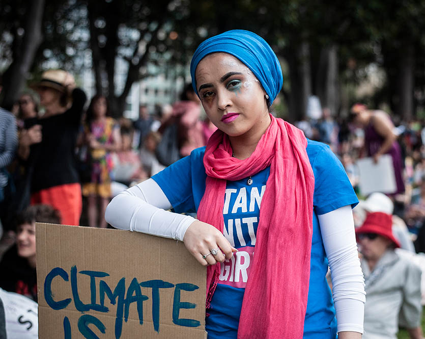 Girl holds 'Climate is changing, why aren't we?' sign at climate strike action in Melbourne