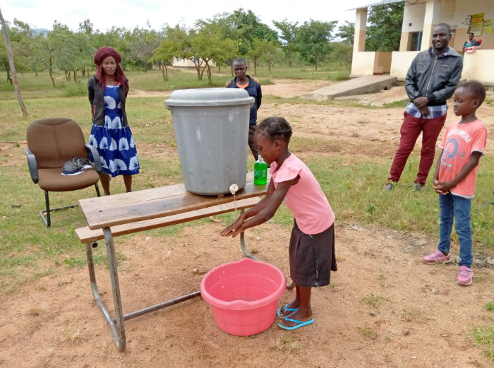 Girl in Zambia demonstrating handwashing