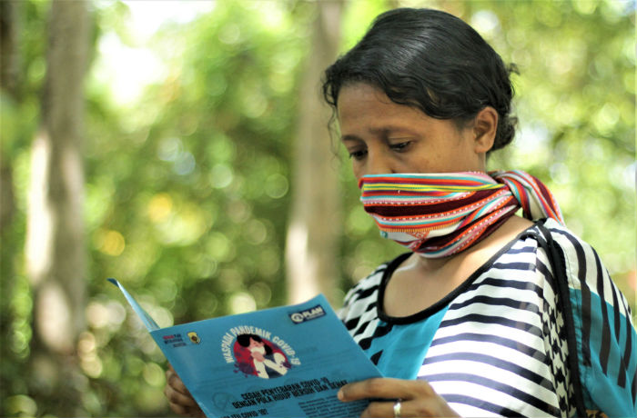 Woman reading COVID-19 leaflet