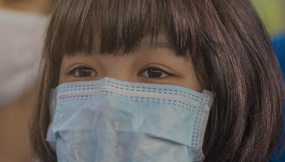 Girl wearing a face mask to protect herself from COVID-19