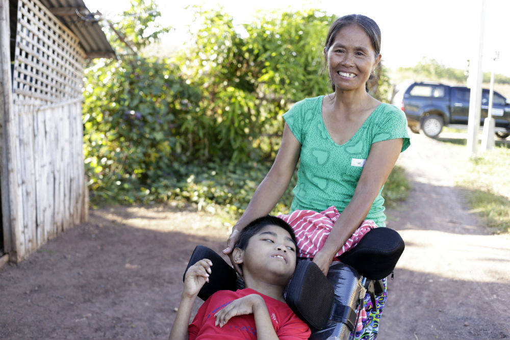 Vilma takes her son out in the wheelchair provided by Plan International
