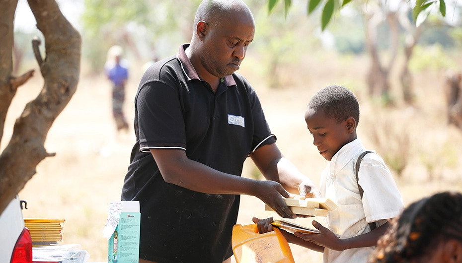 Boy receives bars of soap as part of Plan International response