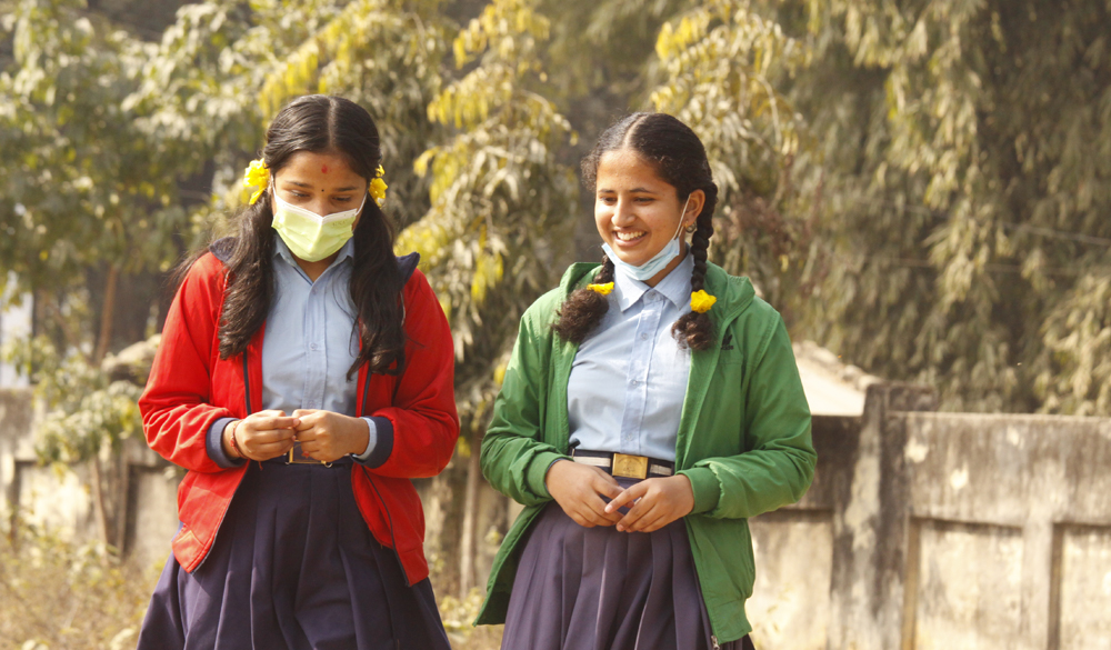 Girls wear masks at their school to prevent the spread of COVID-19