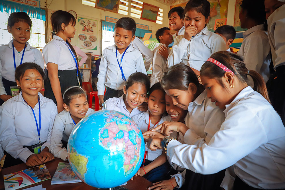 Children use globe to learn geography at primary school in Siem Reap