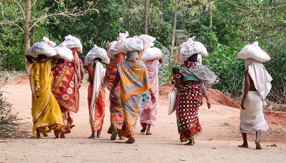 Women carry their food kits home on their heads in Odisha state