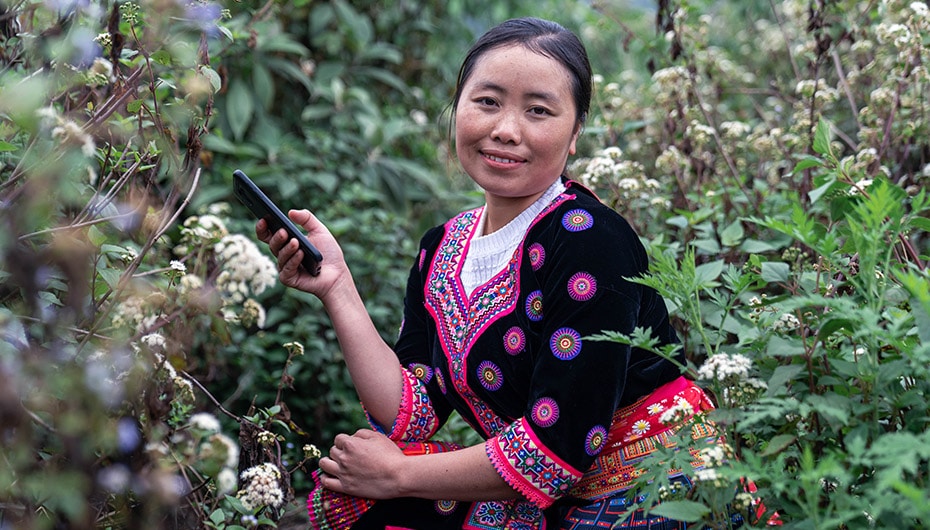 Young woman in Vietnam uses mobile phone to access EMPoWR project