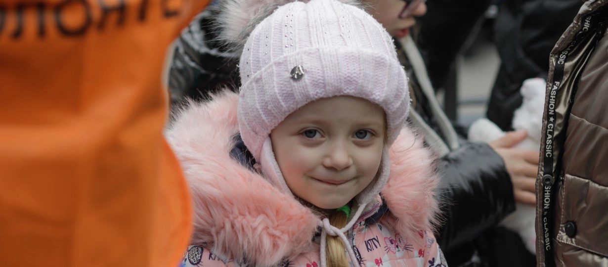 Julia, 5, clutches the toy rabbit she has received after arriving in Isaccea