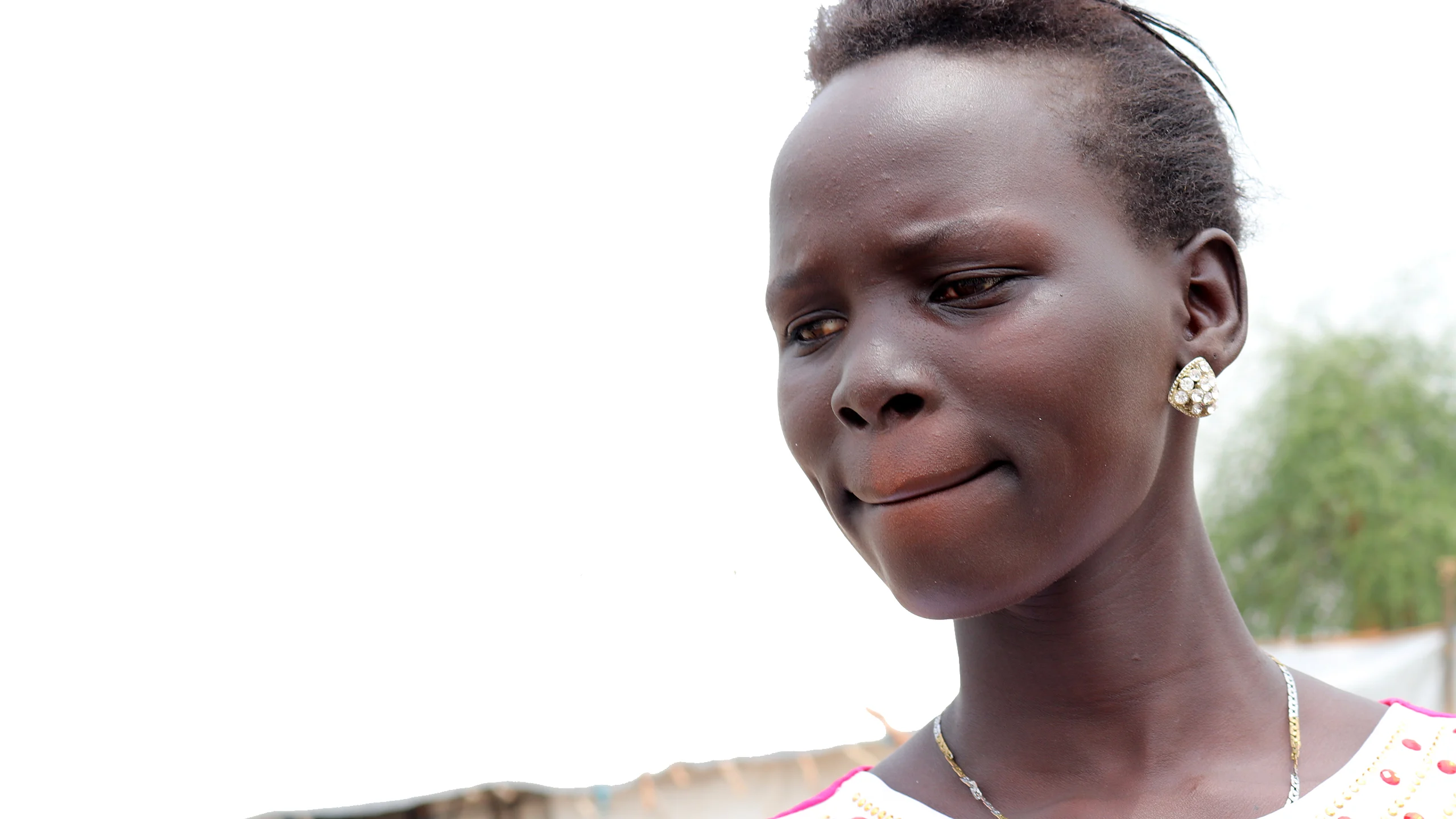 Close up of woman with a gold earing looking at the ground.
