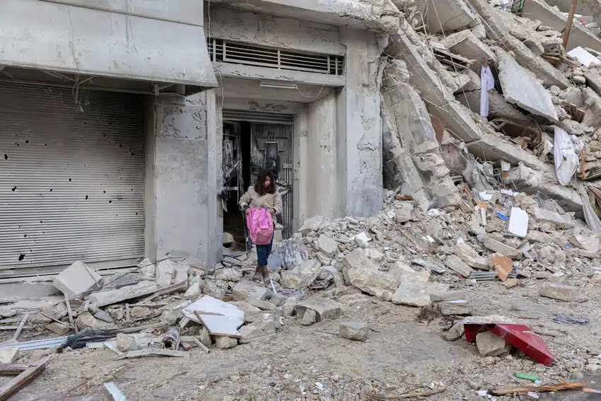 Woman salvages some possession from badly damaged building in Aleppo, Syria