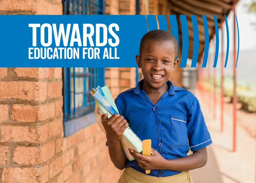 A boy outside a classroom with the heading: Towards education for all