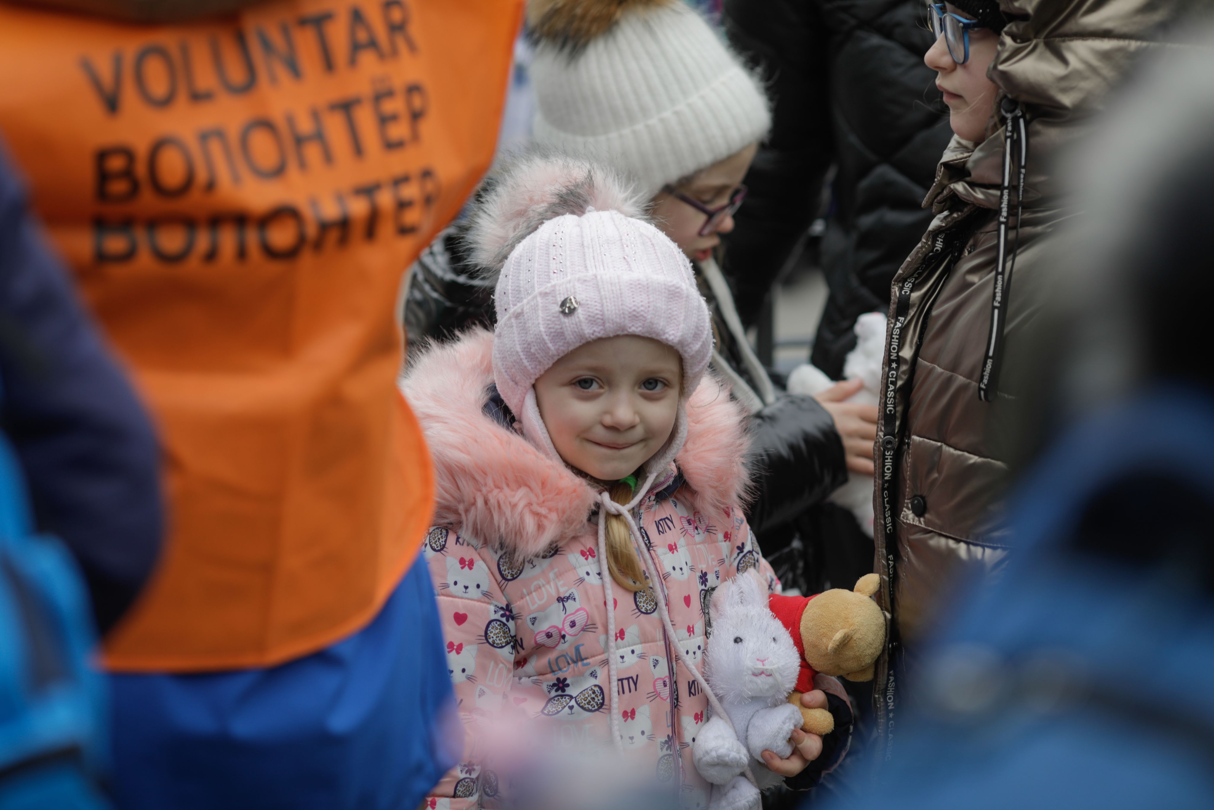 Julia, 5, clutches the toy rabbit she has received after arriving in Isaccea.