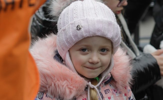 Julia, 5, clutches the toy rabbit she has received after arriving in Isaccea
