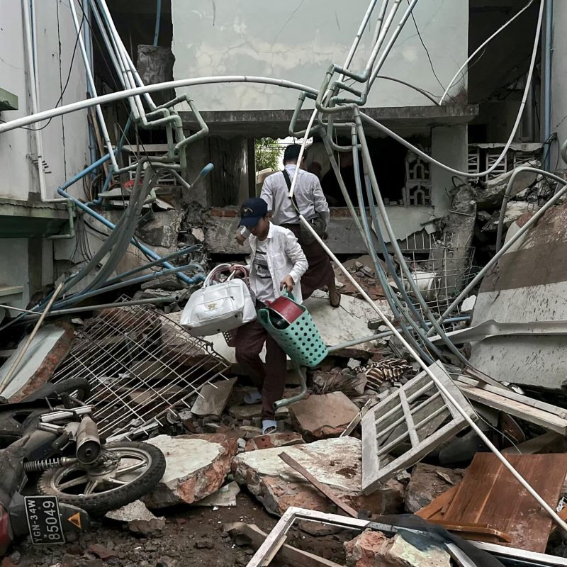 A resident carries belongings over rubble of damaged building in Naypyidaw on 28 March 2025, following an earthquake in central Myanmar. The powerful earthquake struck central Myanmar, buckling roads in the capital Naypyidaw, damaging buildings and forcing people to flee to neighbouring Thailand.